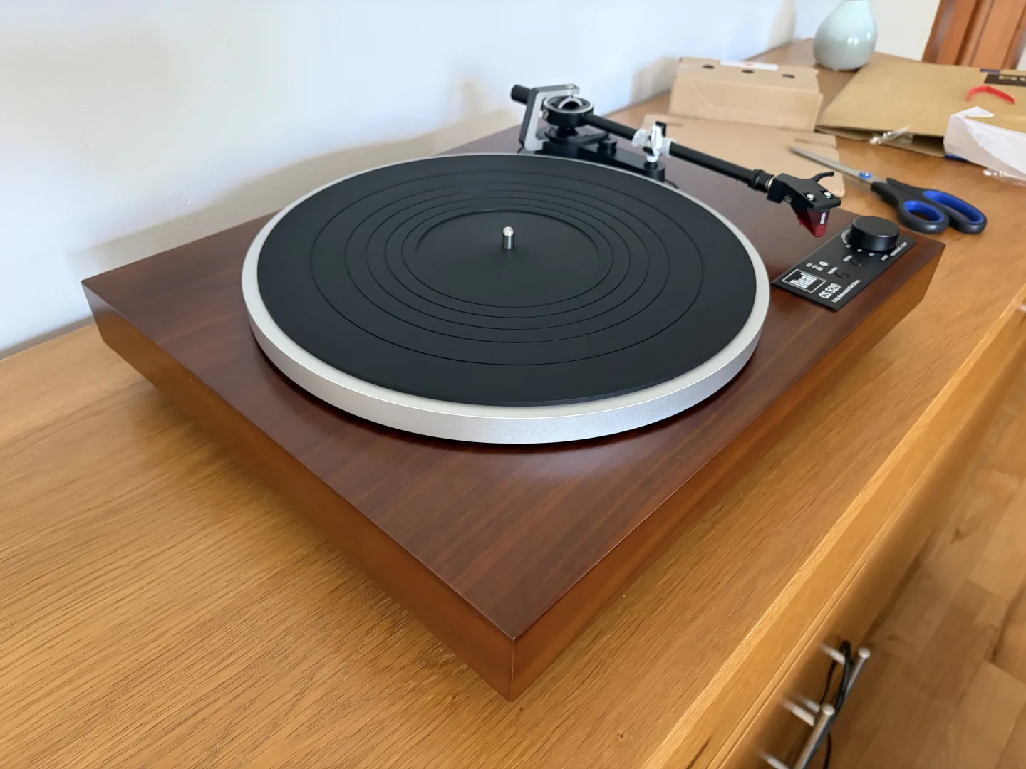 Platine vinyle Dual CS 529 BT vue en perspective, plateau et tapis en place, posée sur un meuble en bois