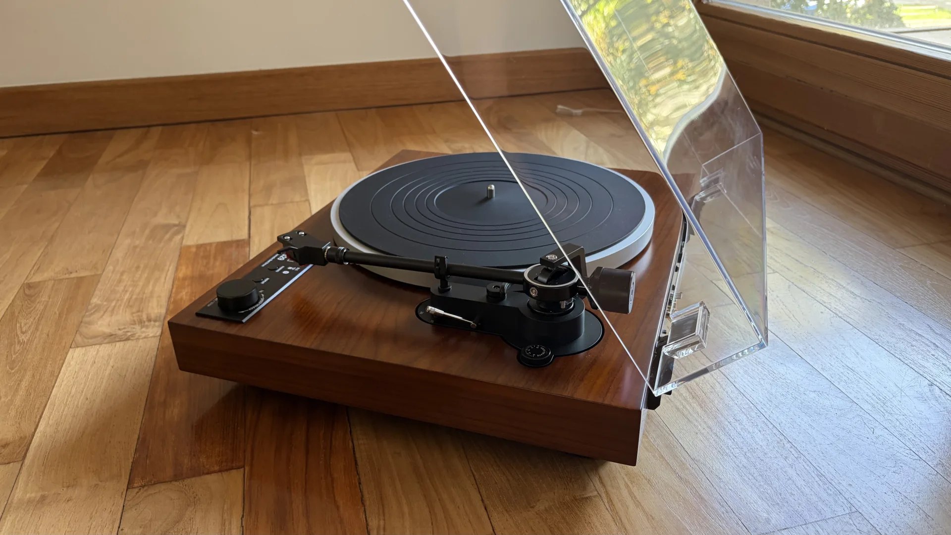 Platine Dual CS 529 BT posée sur un parquet avec son capot transparent relevé