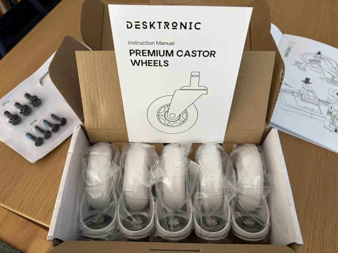 Boîte de roulettes Desktronic Premium Castor Wheels pour parquet, avec notice et vis, livrée avec la SitOne