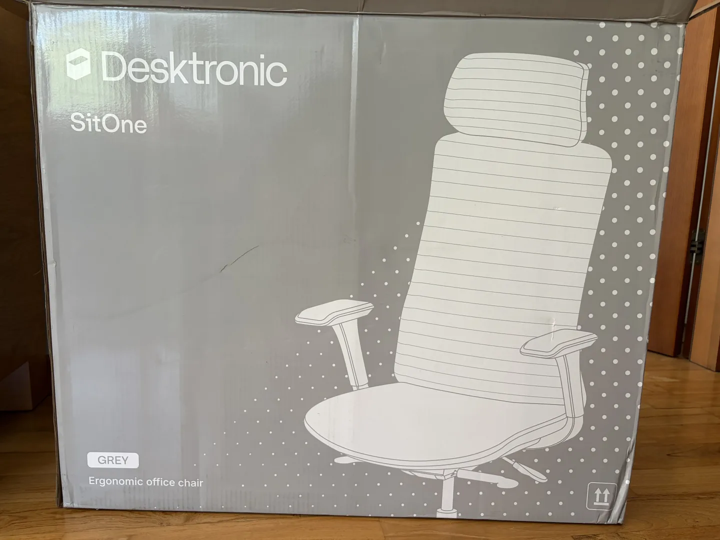 Carton de la chaise ergonomique Desktronic SitOne en coloris gris, en bon état à la livraison