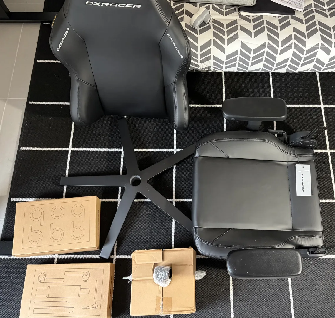 Éléments déballés de la DXRacer Craft disposés sur le sol avec outils