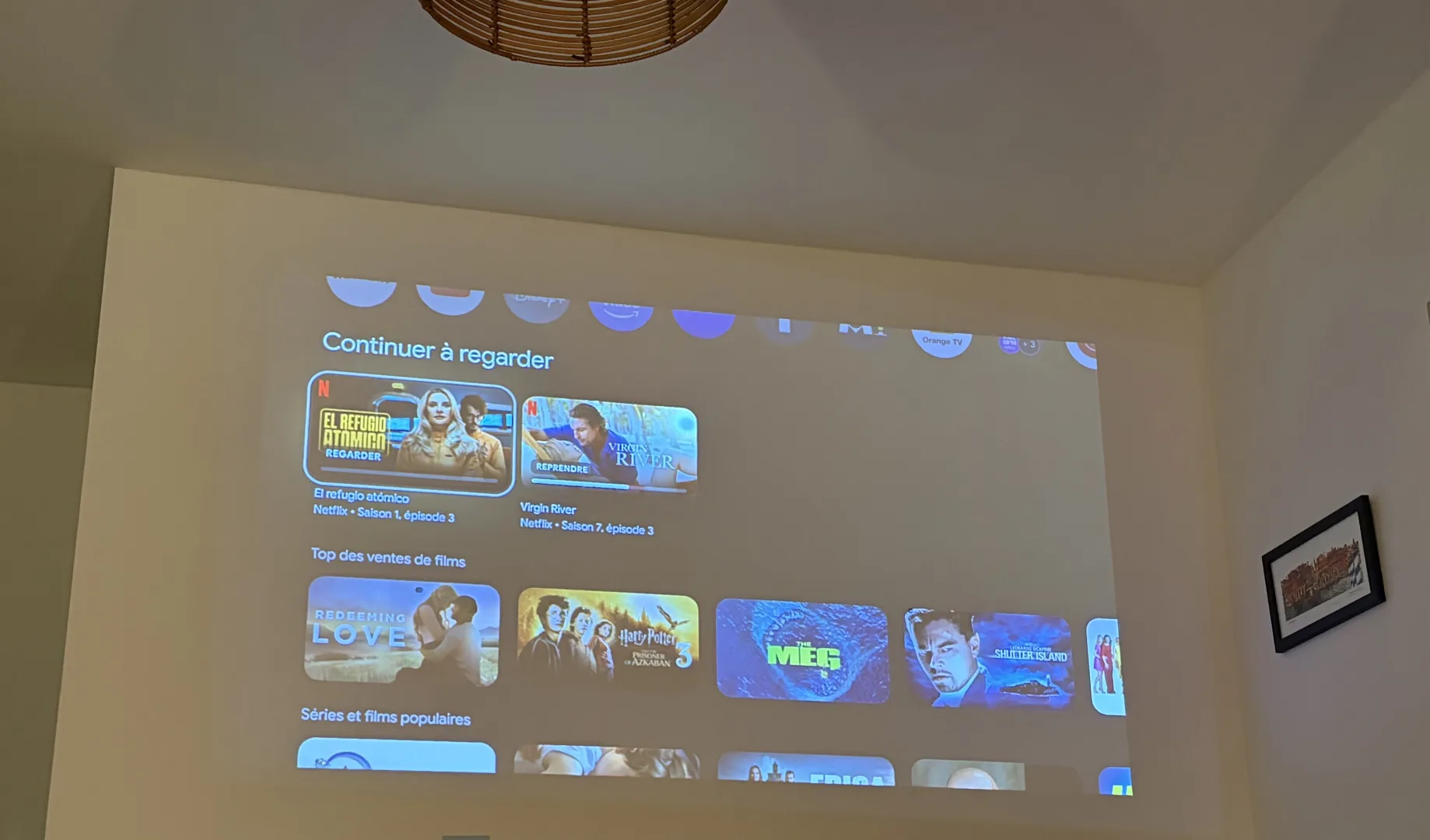 écran XGIMI Halo+ avec deux lampes de chevets allumées