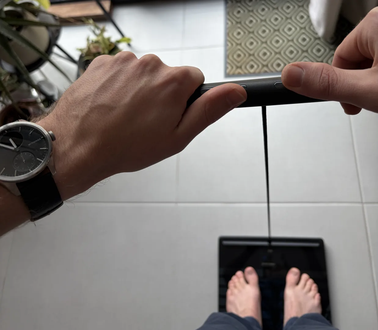 Utilisation en situation : pieds sur le plateau, mains sur la poignée, ScanWatch 2 au poignet